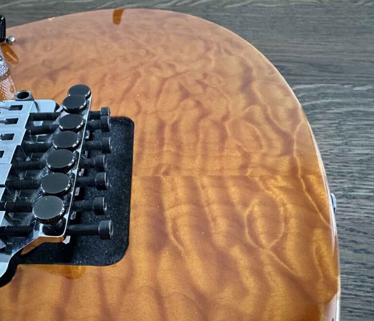 A bookmatched quilted maple body on a Suhr electric guitar.