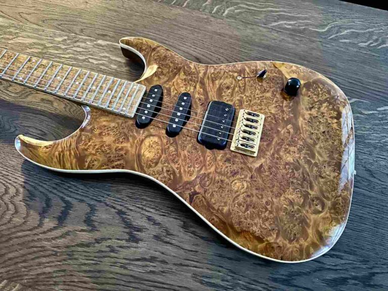 A one-piece burl maple body on an electric guitar.