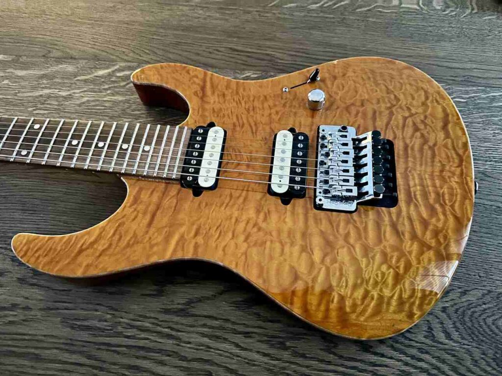 A two-piece quilted maple top on a Suhr Modern seven-string electric guitar.