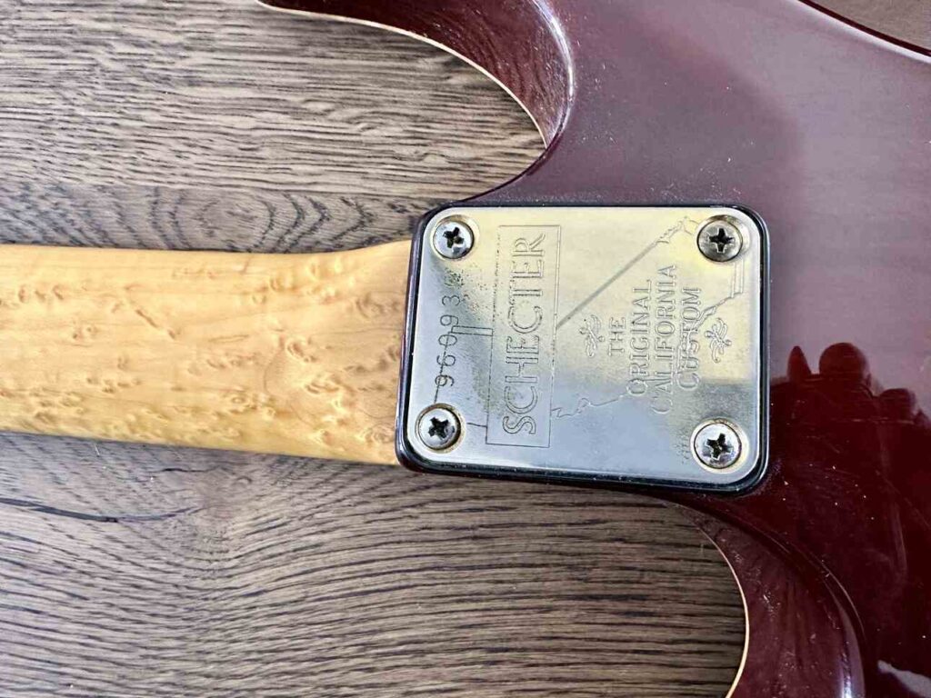Closeup of the backside of a bolted on 22-fret neck on a Schecter Hollywood Custom ltd electric guitar.