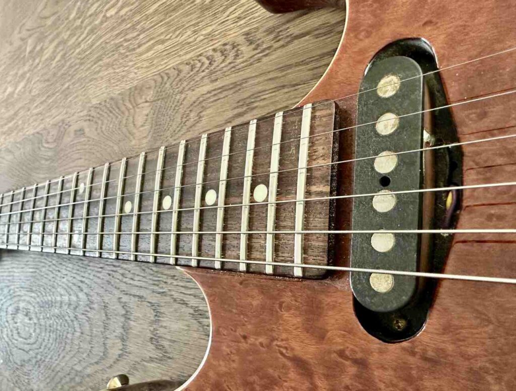 Closeup of a bolted on 22-fret neck on a Schecter Hollywood Custom ltd electric guitar.