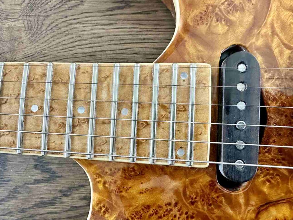 Closeup of the end of a 24-fret neck on a custom made electric guitar.
