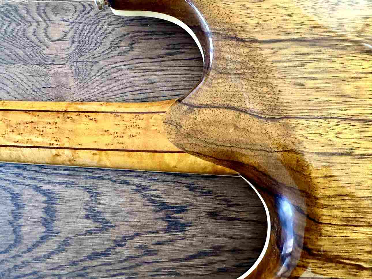 Closeup of a glued on 24-fret neck on a custom made electric guitar.