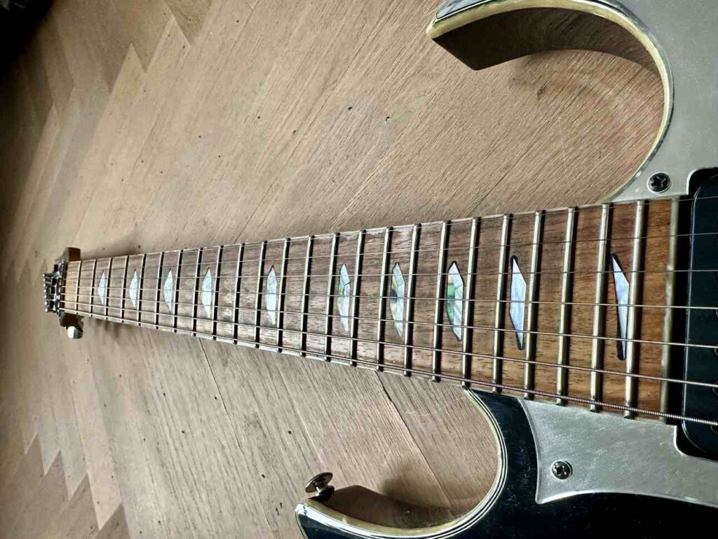 Closeup of the guitar neck of an Ibanez Universe, emphasizing the fret spacing.