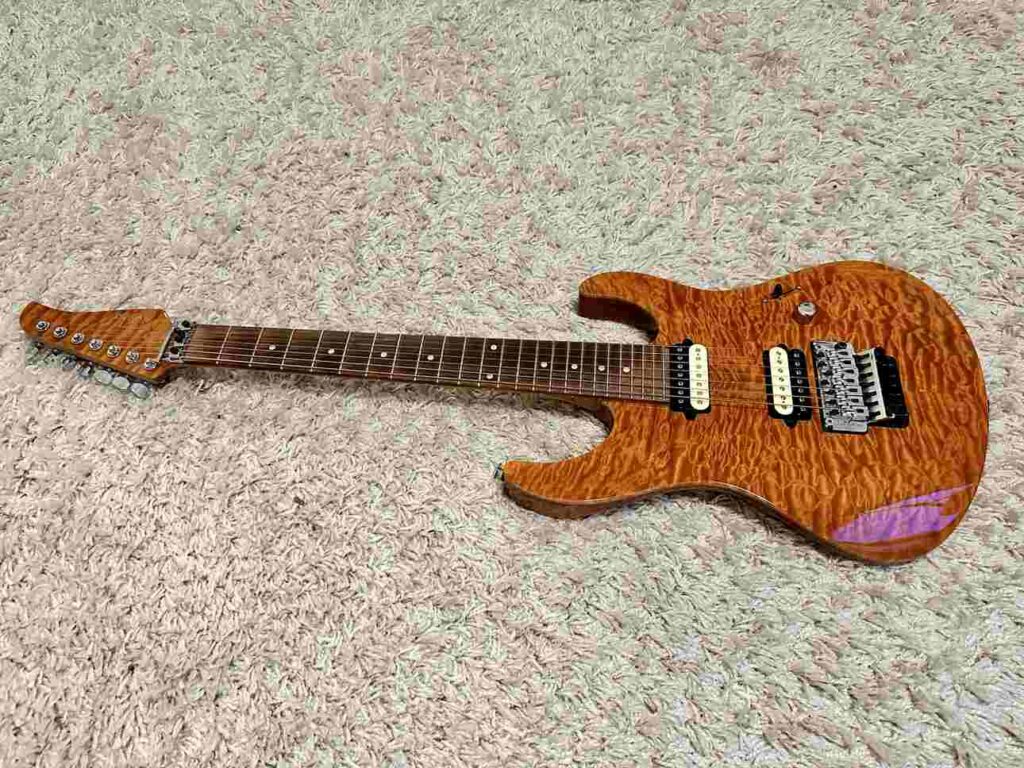 Suhr Modern 7 string electric guitar with 24 frets on a carpet.