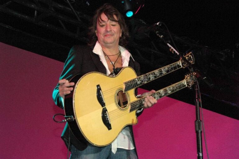 Richie Sambora, formerly of Bon Jovi, playing a twin-necked acoustic guitar on stage.