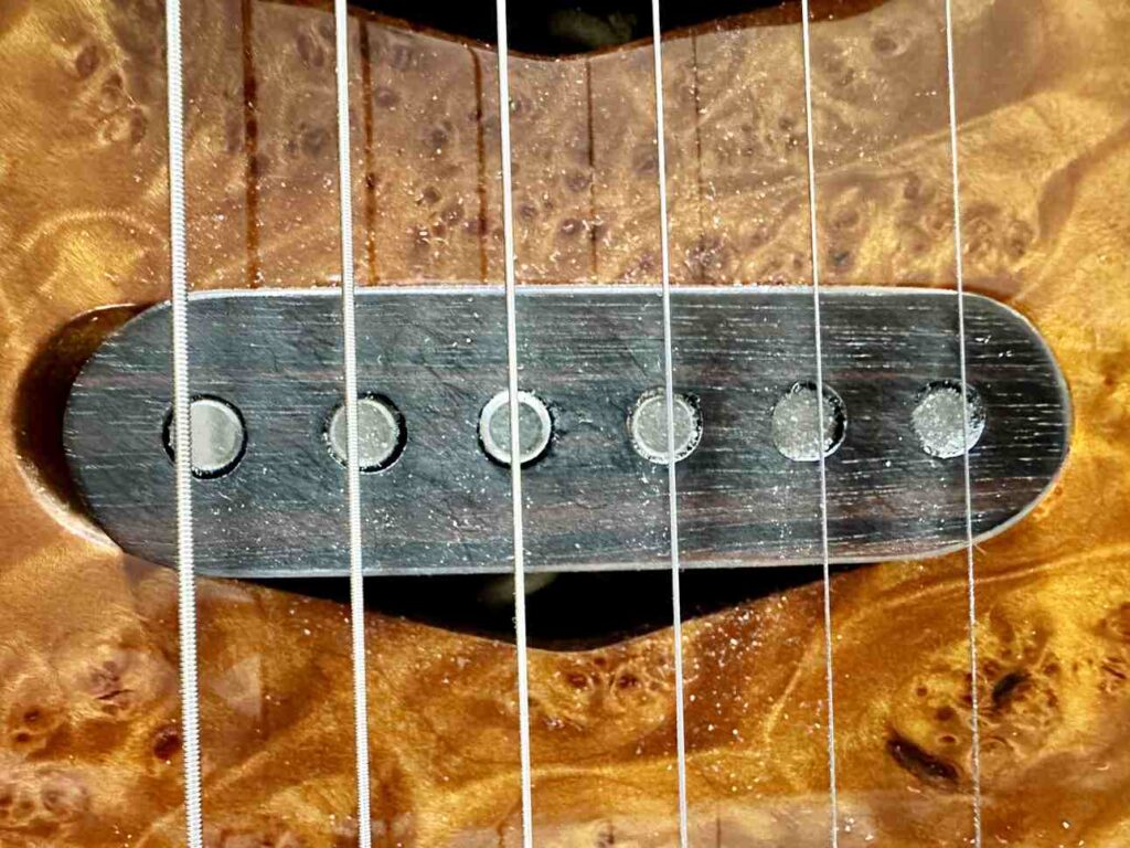 Extreme closeup of a Lindy Fralin single coil pickup on a custom-built electric guitar.