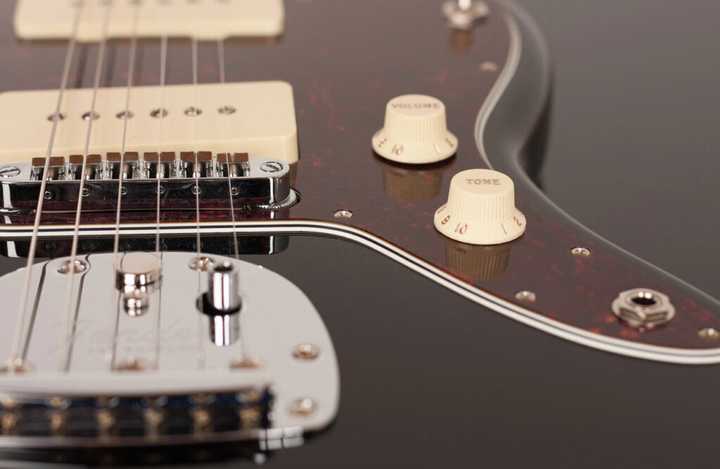 Closup of two white P90 single coil pickups on a Fender Jaguar electric guitar.