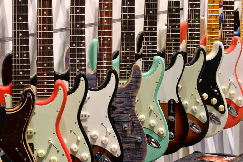 Stratocaster type guitars hanging on the wall in a guitar shop.