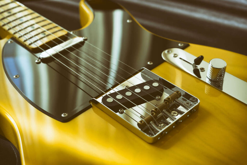 Slanted bridge saddles on a yellow Fender Telecaster.