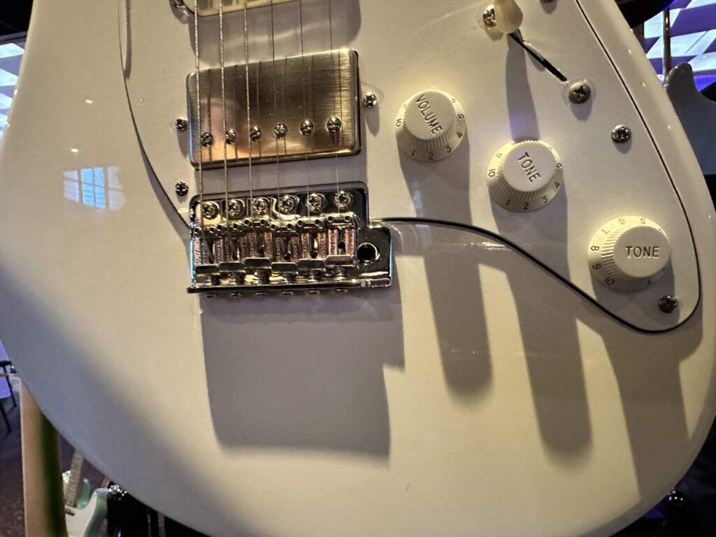 Closeup of a Fender Stratocaster body with a solid white finish.