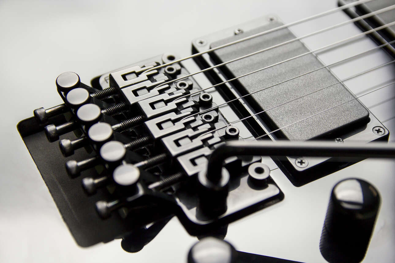 A black superstrat style guitar equipped with a black Floyd Rose bridge.