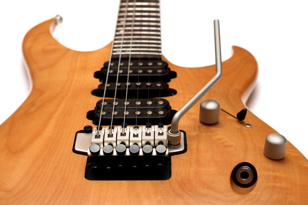 A brown superstrat style guitar equipped with a silver color Floyd Rose bridge.