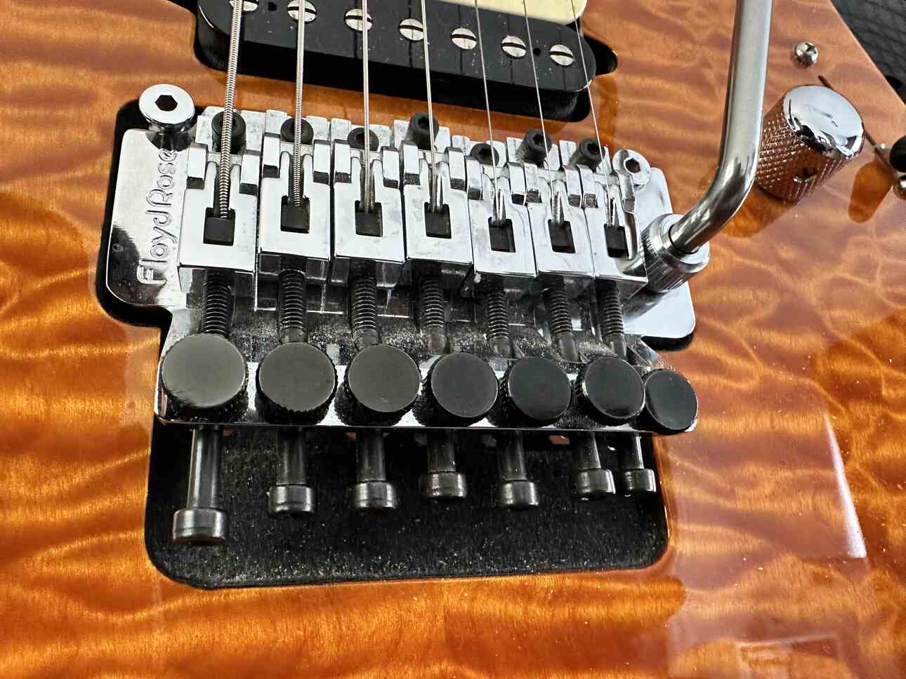 A Floyd Rose bridge on a Suhr Modern 7 string electric guitar.