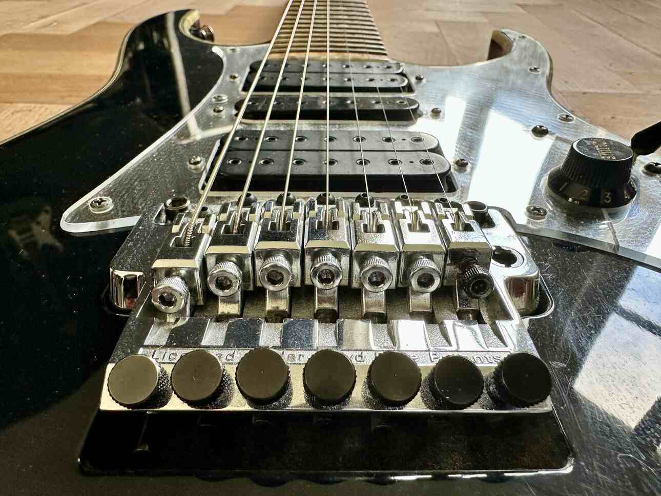 A closeup of a seven string Ibanez Universe BK, seen from behind the bridge.