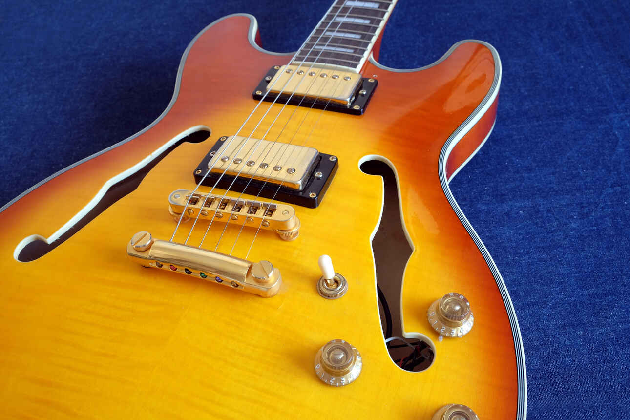 A Gibson ES335 hollow body guitar on a blue background.